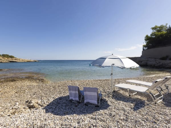 A path to one side of the property leads out onto a shingle beach.